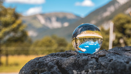 Fototapeta na wymiar Crystal ball alpine landscape shot at the big maple ground- Austria