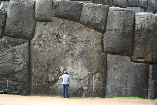 The gigantic boulder of Sacsayhuaman show the scale of it with human being. It perfectly fitted together with other stones. This is the Inca ruin located on the mountain top next to Cuzco, Peru