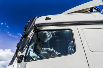 The sky reflected in the glass of the truck