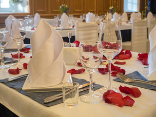 Table served with glasses and rose petals in the restaurant.

