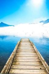 Morning fog on Pier of lake Mondsee and Alps in Austria