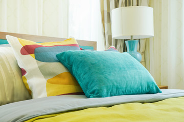 Closeup yellow and green pillows on bed in modern interior bedroom