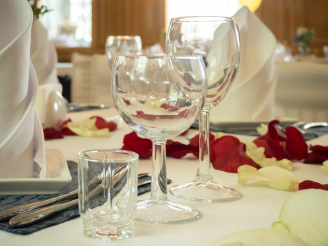 Table served with glasses and rose petals in the restaurant.
