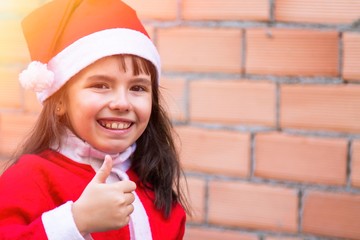 little girl with raised thumb congratulating christmas