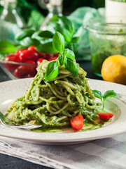 Pasta spaghetti with homemade basil pesto sauce on white plate