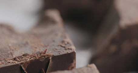 closeup breaking dark chocolate block with knife