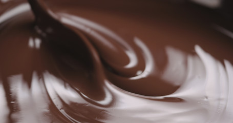 closeup stirring molten dark chocolate with spoon