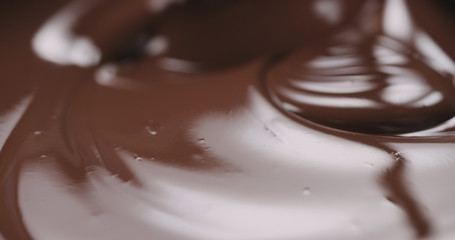 closeup stirring molten dark chocolate with spoon