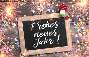 Kreidetafel mit Konfetti Marienkäfer und Glückspilz Fliegenpilz Happy New Year mit Wunderkerzen
