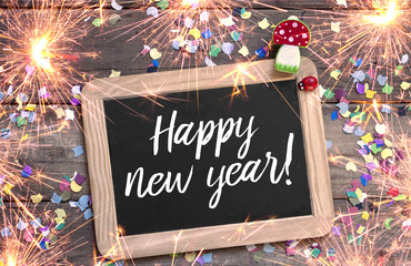 Kreidetafel mit Konfetti Marienkäfer und Glückspilz Fliegenpilz Happy New Year mit Wunderkerzen