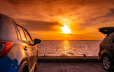 Black and blue SUV car with sport and modern design parked on concrete road by the sea at sunset. Environmentally friendly technology. Road trip travel on vacation at the beach and open car truck