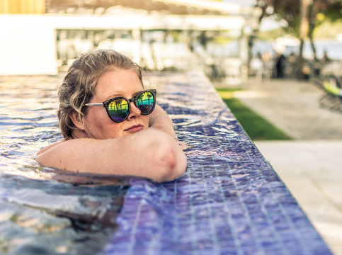 young woman wearing sunglasses at swimming pool