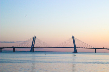 Fototapeta na wymiar bridge across the Bay, suspension bridge, bridge and evening sunset, urban landscape, metal construction