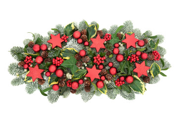 Christmas table decoration with red bauble decorations, winter flora of holly berries, snow covered...