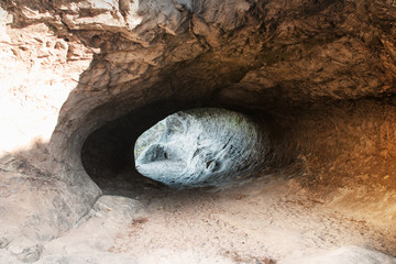 A mysterious cave in a sand stone rock landscape at colorful sunset light. Sandstone rock formation Teufelsmauer (Devil's Wall) in Blankenburg, National park Harz in Germany, Harz Mountains.