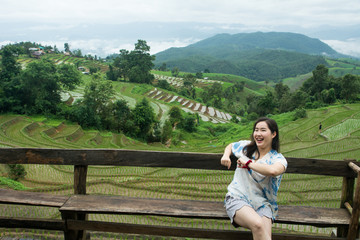 Fototapeta na wymiar The pretty woman relaxing in holiday at rice terrace, Rice planting season in Chiang Mai, Tourism concept