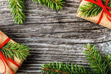 Holiday frame banner with christmas gift boxes, presents and fir tree branches, flat lay on wooden rustic background, mockup