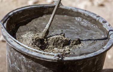 Mixing of concrete in a bucket at a construction site