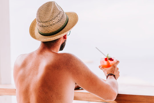 Young man enjoying cocktail in a beach bar