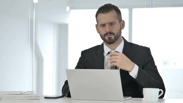 Tired Businessman with Neck Pain at Work