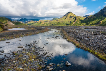 Fototapeta premium Glacial river in the dramatically beautiful and surreal landscapes of Thorsmork valley in the Highlands of Iceland at southern end of the famous Laugavegur hiking trail.