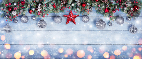 Christmas Baubles With Star In Fir Branches On Snowy Wooden Plank

