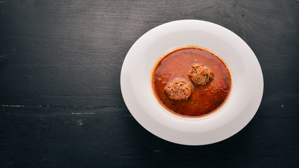 Vegetable soup with meat balls. On the old wooden background. Free space for text. Top view.