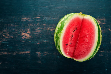 Fresh watermelon Fruits. Melon. On a black wooden background. Free space for text. Top view.