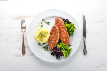 Cutlets of meat with mashed potatoes on a plate. On the old wooden background. Free space for text. Top view.