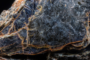 Biotite (black mica) mineral on black background. - obrazy, fototapety, plakaty