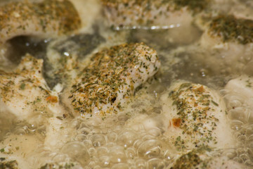 Chicken fillet with seasonings fried in a frying pan