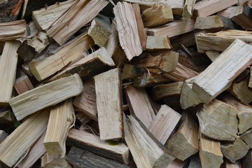 Closeup photograph of a pile of freshly cleaved firewood (oak and beech).