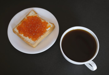 Sandwich with red caviar and coffee. Selective focus.