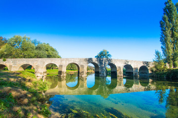 Fototapeta na wymiar Old stone bridge on the river Dobra in Karlovac county, Croatia
