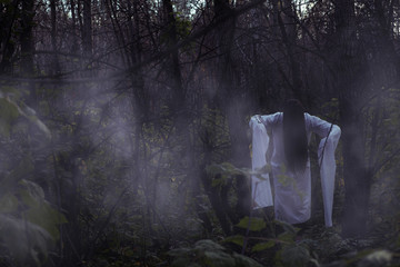 Portrait of a dead girl on Halloween in a gloomy forest.