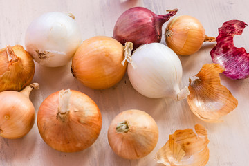 Onions of different colors on the table - white, red, yellow