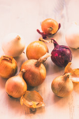 Onions of different colors on the table - white, red, yellow
