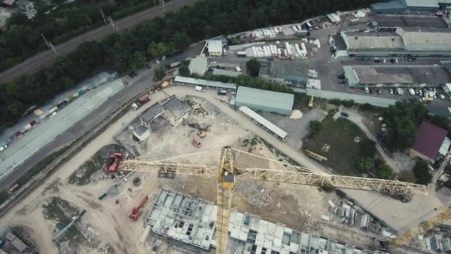 Aerial Drone Flight 4k Footage: The construction crane and the building against the blue sky. Flying over construction of several houses with building cranes.