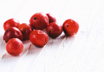 Heap of dried pink pepper berries on white wooden table. Close up view of pink peppercorn. Copy space.