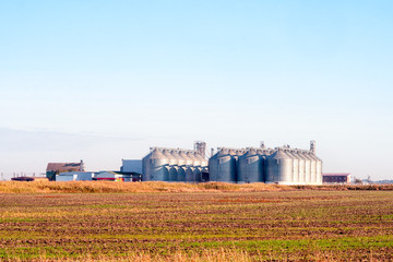 Fototapeta na wymiar grain elevator buildings in the field. agriculture landscape.