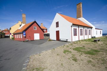 Small colorful half-timbered houses with smokery chimneys in Gudhjem, Bornholm, Denmark