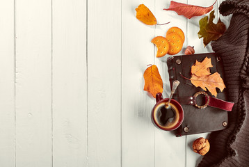 Cup coffee with book in leather binding autumn dry leaf and warm