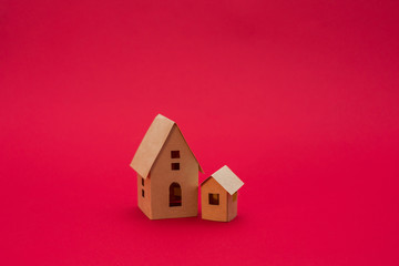 Obraz na płótnie Canvas two paper houses, red background with copy space, for advertising, side view, close up