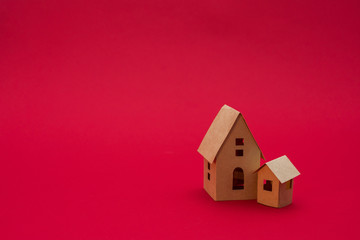 two paper houses, red background with copy space, for advertising, side view, close up