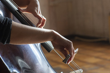 Hands of a musician playing on a contrabass closeup