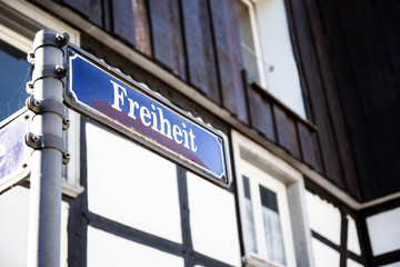 Fototapeta na wymiar A freedom street blue and white street sign in a old german town hattingen