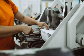 Close up shot of worker's hand preparing carton for printing in a modern printing house.