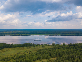 Fototapeta na wymiar Aerial view of river Volga and cruise ship sailing along. Green riversides and meadows. Summer photo from drone, Russia