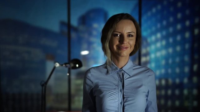 Beautiful young business woman looking at the camera in the modern high teck office. New technology, business, finance