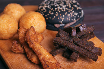 Croutons, snacks and burger on a wooden background, fast food.